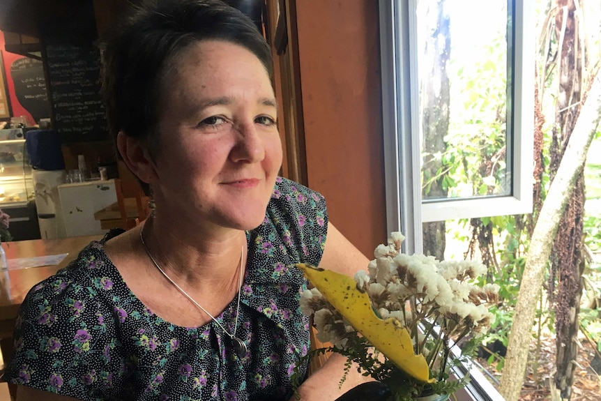 Eve Semple is pictured by a window in a cafe on Norfolk Island.