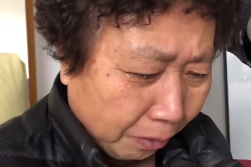 A Chinese woman with short curly hair crying