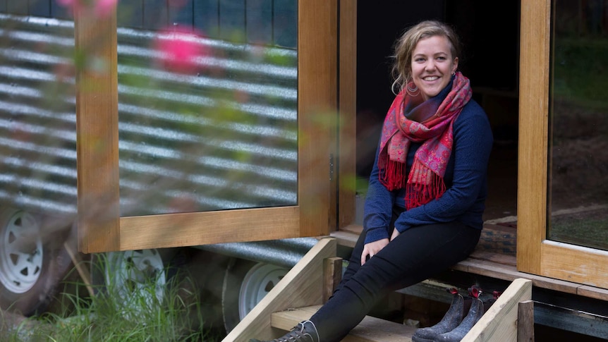 Sarah Smethurst sits on the stairs of her home.