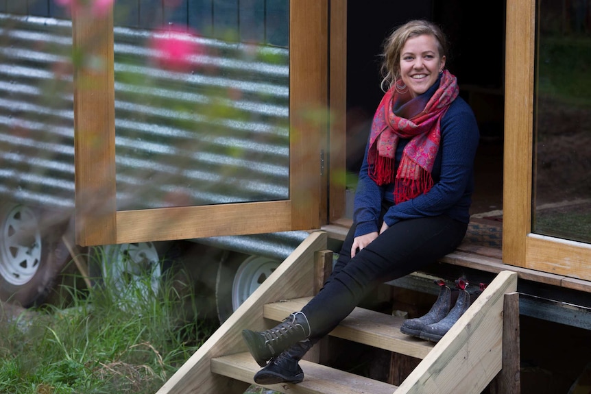 Sarah Smethurst sits on the stairs of her home.