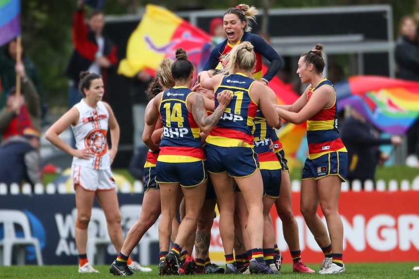 A number of Crows players celebrate together in a pack