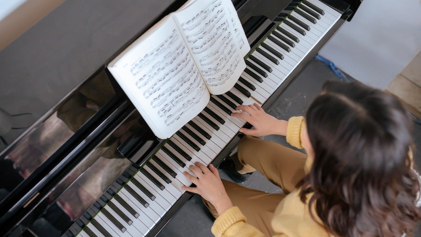 a piano with a player's hands on the keyboard