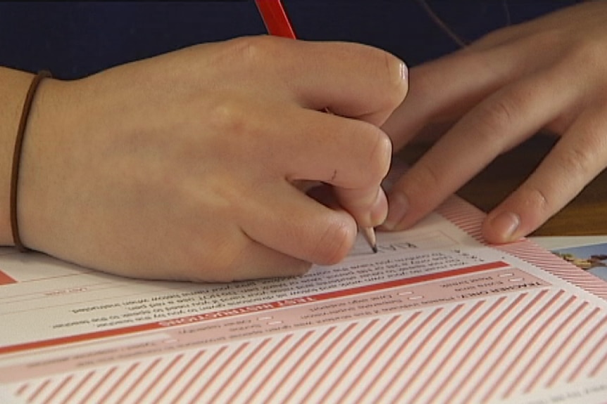 An unidentified child writes on a NAPLAN testing paper