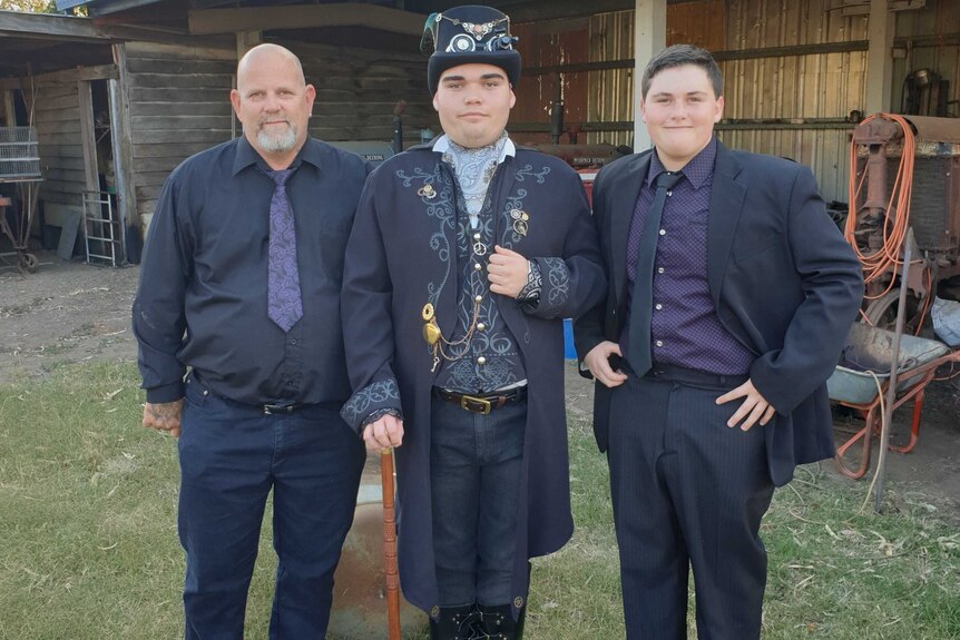 Will Barabas, Liam Mears and Adam Mears in formal attire, standing side by side in a backyard.
