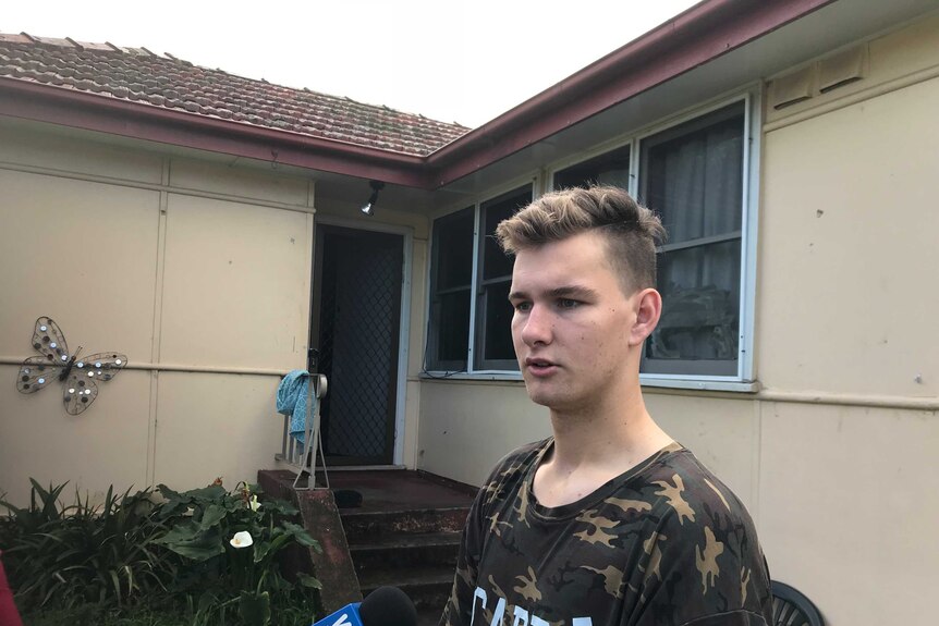 Ryan Shimwell stands in front of his home directly across the road from the fatal house fire