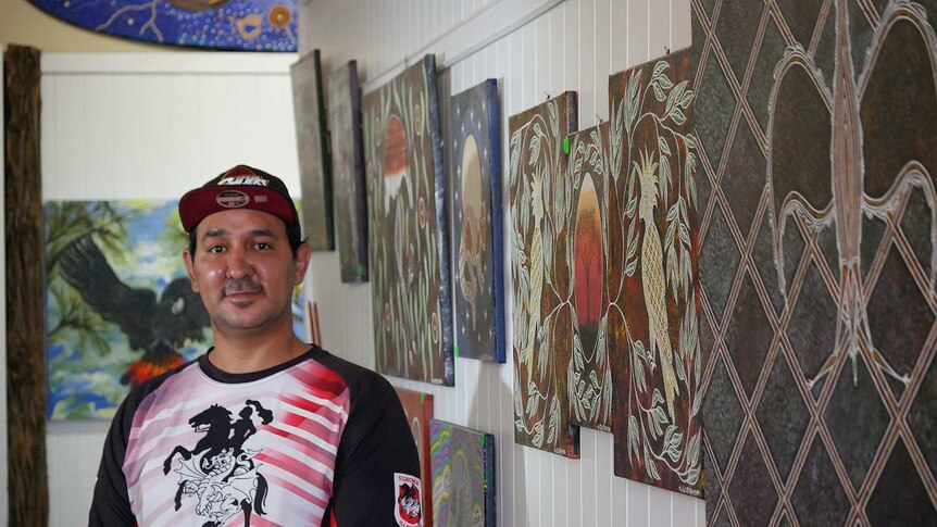 Mani Tribes Gallery Manager Gordon Lister standing in the gallery in front of art work in St George, Queensland.