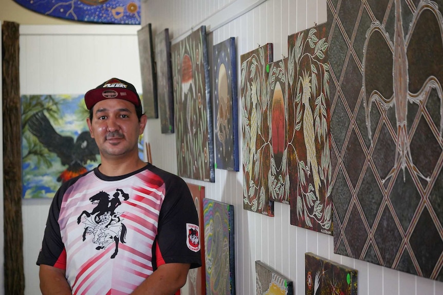 Mani Tribes Gallery Manager Gordon Lister standing in the gallery in front of art work in St George, Queensland.