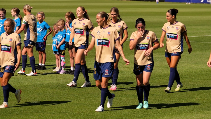 A soccer team on the field. Emily Van Egmond, from the Matildas, is playing.