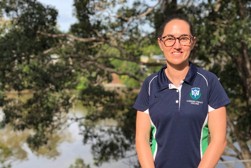Brisbane Lions player Sharni Webb wears glasses with school shirt on at college she teaches at.