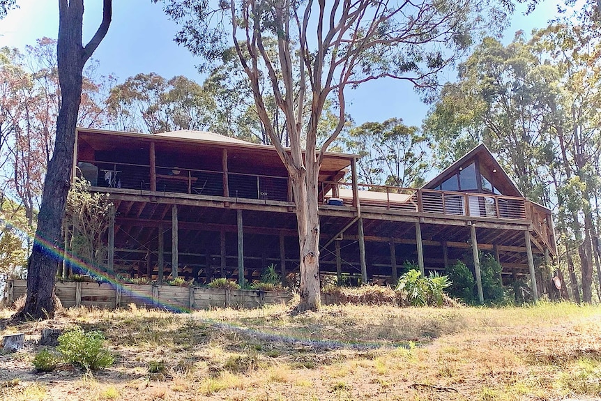 The holiday house where Tracey Corbin-Matchett's family was staying in Tarbuck Bay. It is surrounded by bush and made of wood.