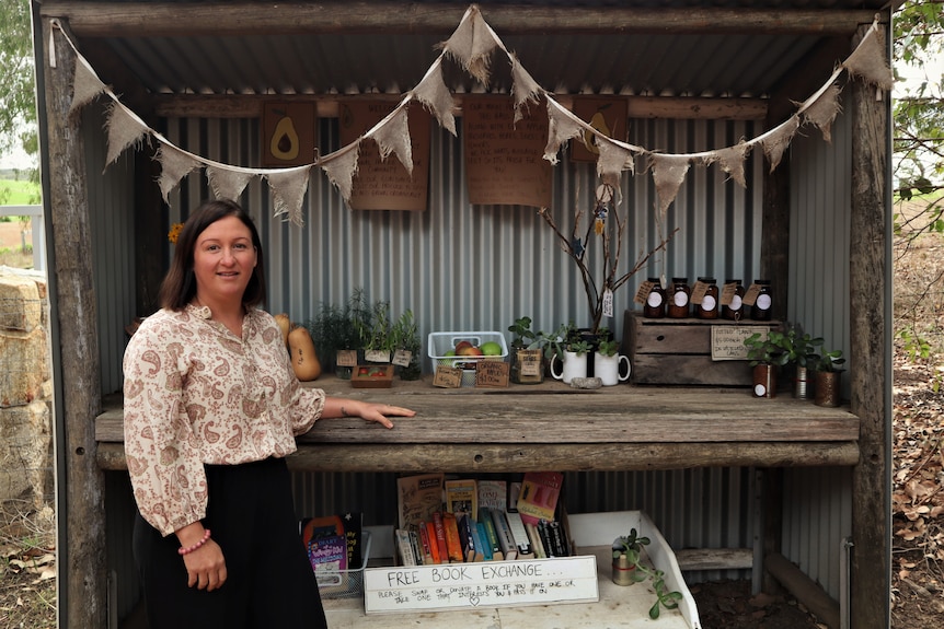 Woman standing with her roadside farm stall.