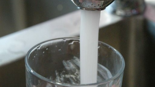 Tap water pouring into a glass.