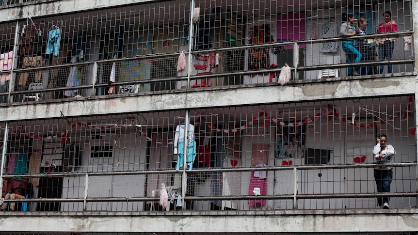 Women watch from the hallways of the prison