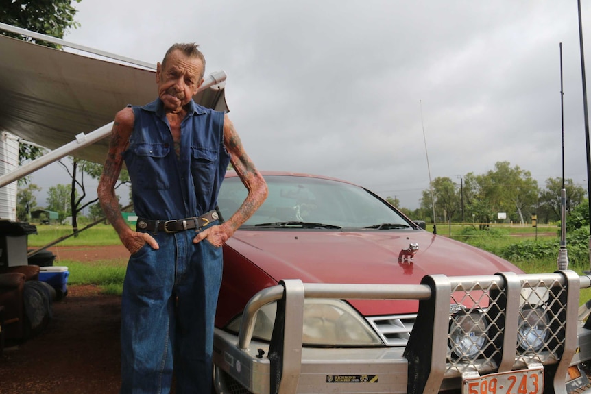 A man poses with his car