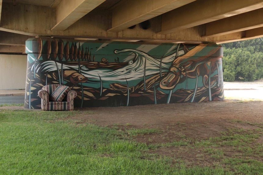 A large mural of platypus is painted on the underside columns of a bridge.