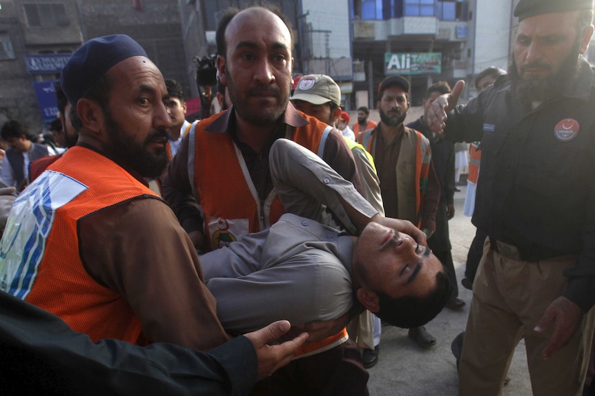 Rescue workers carry a man, who was injured during an earthquake, at the Lady Reading hospital, Peshawar, Pakistan.