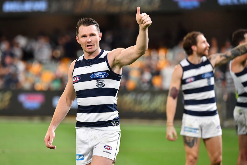 A Geelong AFL players gives the thumbs up with his left hand after defeating Collingwood at the Gabba.