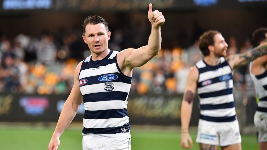 A Geelong AFL players gives the thumbs up with his left hand after defeating Collingwood at the Gabba.
