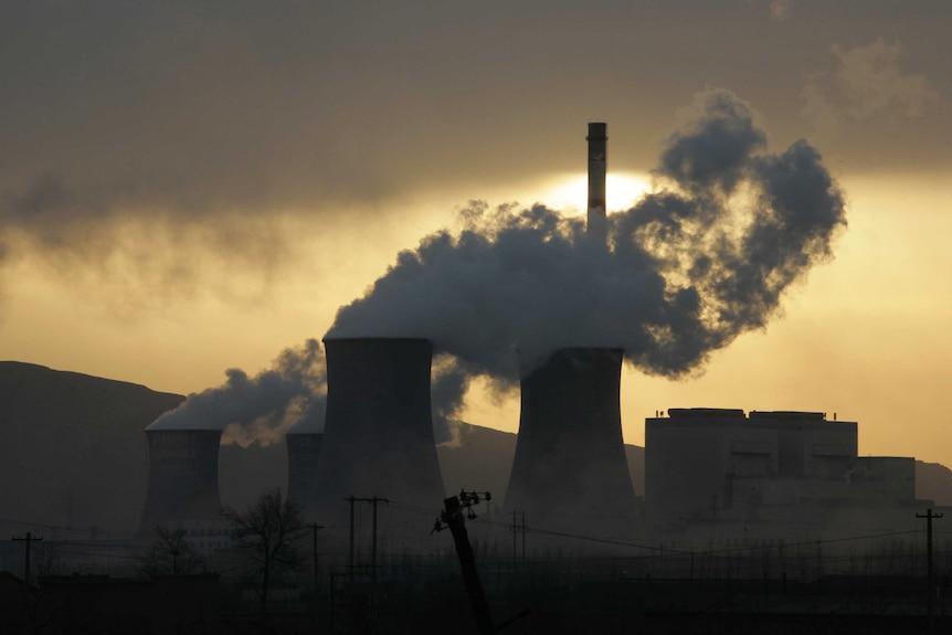 A coal-fired power station in silhouette.