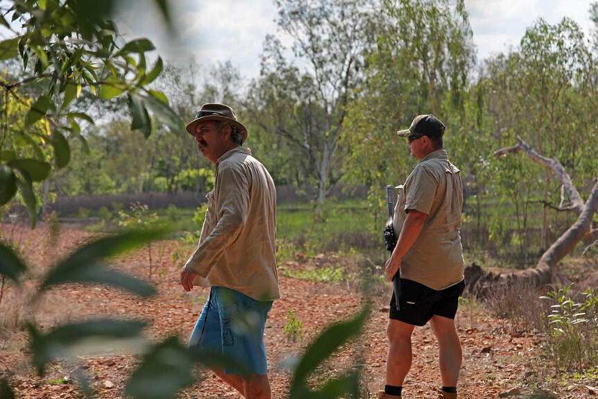 Roger Matthews and Danuel Byrne looking through a cattle station for evidence of a crocodile.
