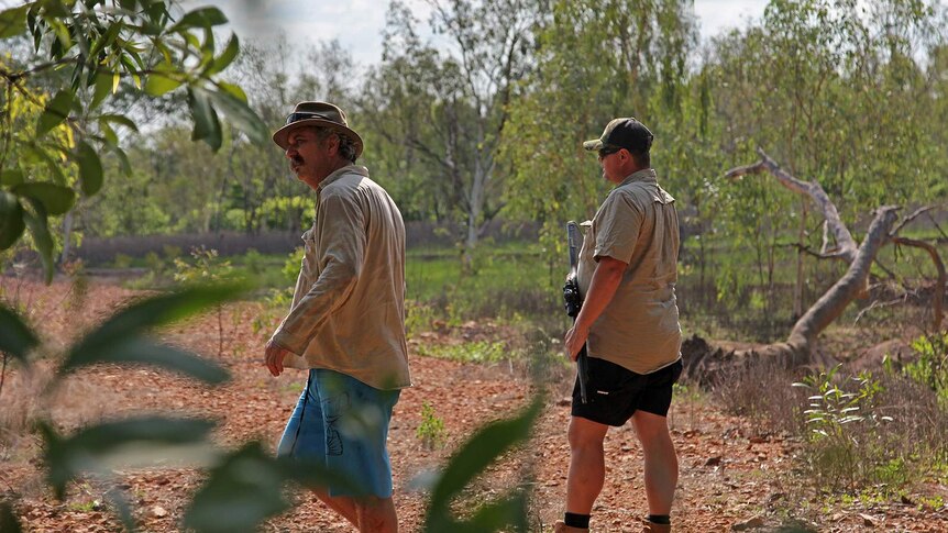 Roger Matthews and Danuel Byrne looking through a cattle station for evidence of a crocodile.