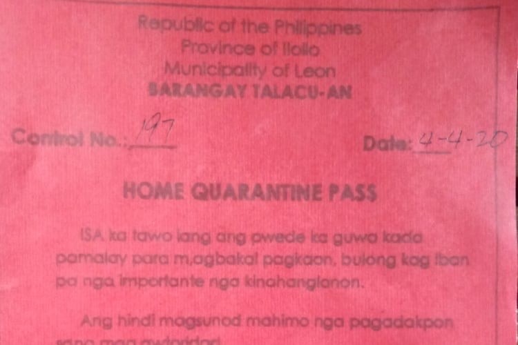 A red card with writing on it showing it is a Home Quarantine Pass