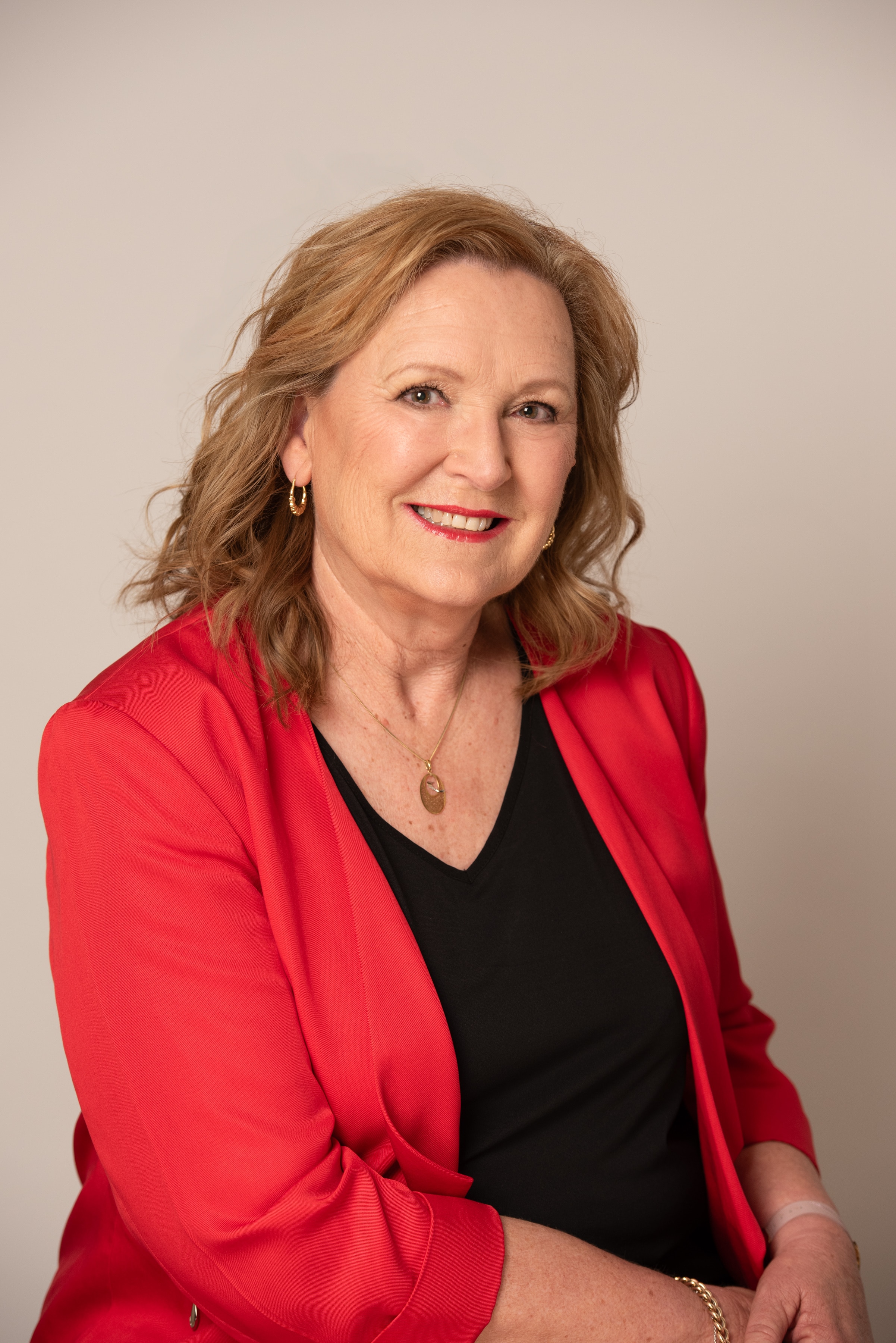 Mulher de meia idade vestindo uma jaqueta vermelha.