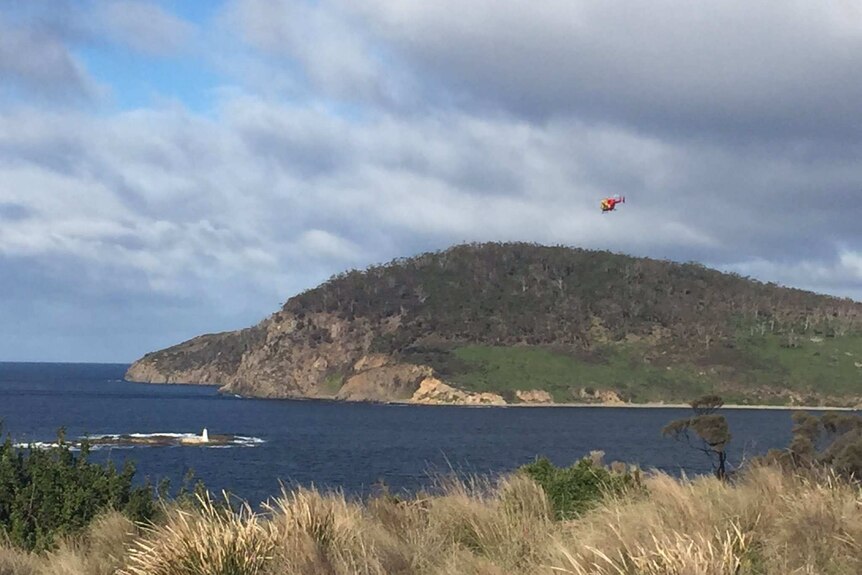 The police chopper flies over Blackjack Rocks near Betsey Island
