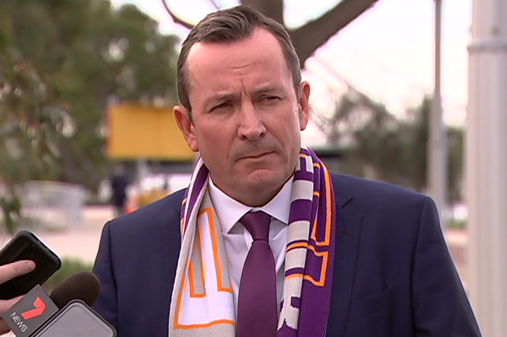 Mark McGowan at a press conference near Perth Stadium, wearing a suit and a Perth Glory scarf.