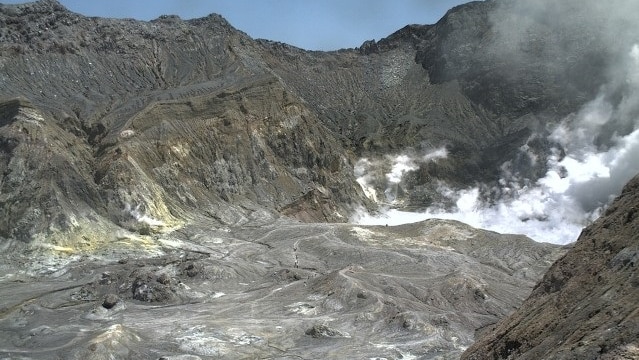 A black crater with smoke in the background.