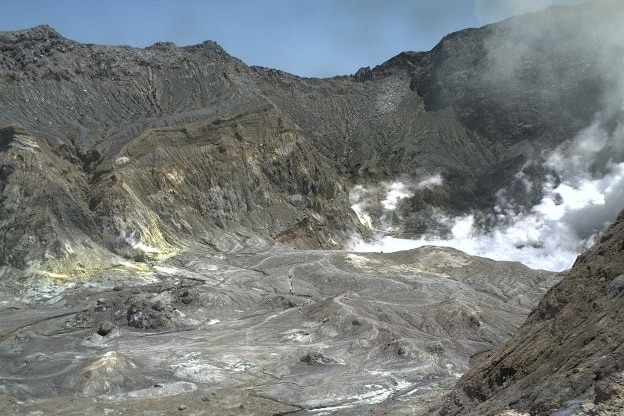 A black crater with smoke in the background.