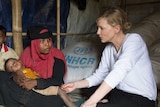 Blanchett sits in a shelter with refugee Jhura and her two children.