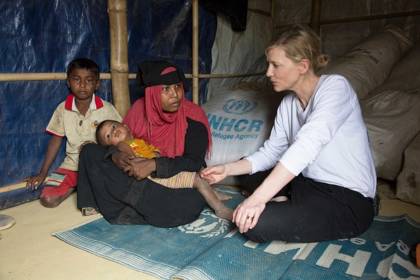 Blanchett sits in a shelter with refugee Jhura and her two children.