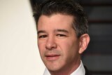 Uber CEO Travis Kalanick glares at the camera while wearing a black suit and tie at the vanity fair oscars event