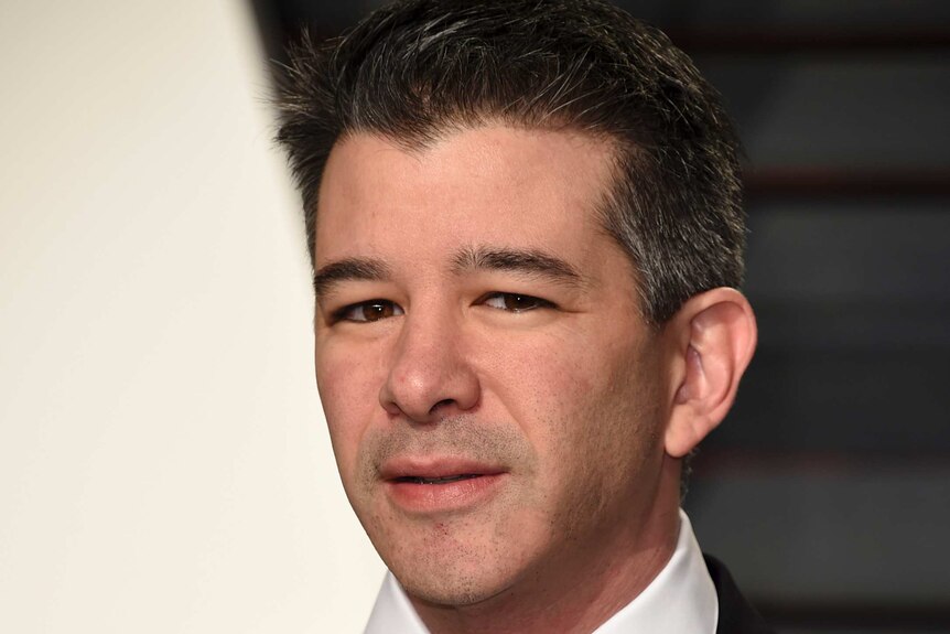 Uber CEO Travis Kalanick glares at the camera while wearing a black suit and tie at the vanity fair oscars event