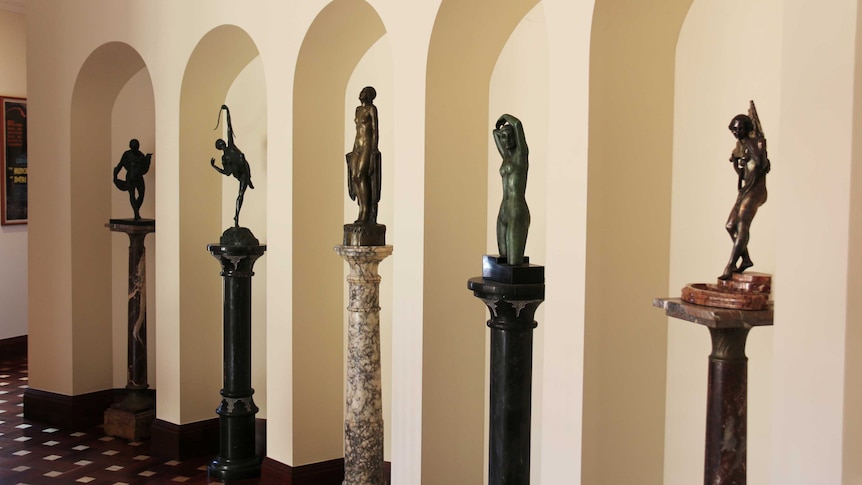 Bronze statues in archways inside a home.