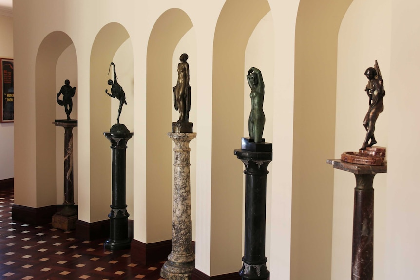 Bronze statues in archways inside a home.