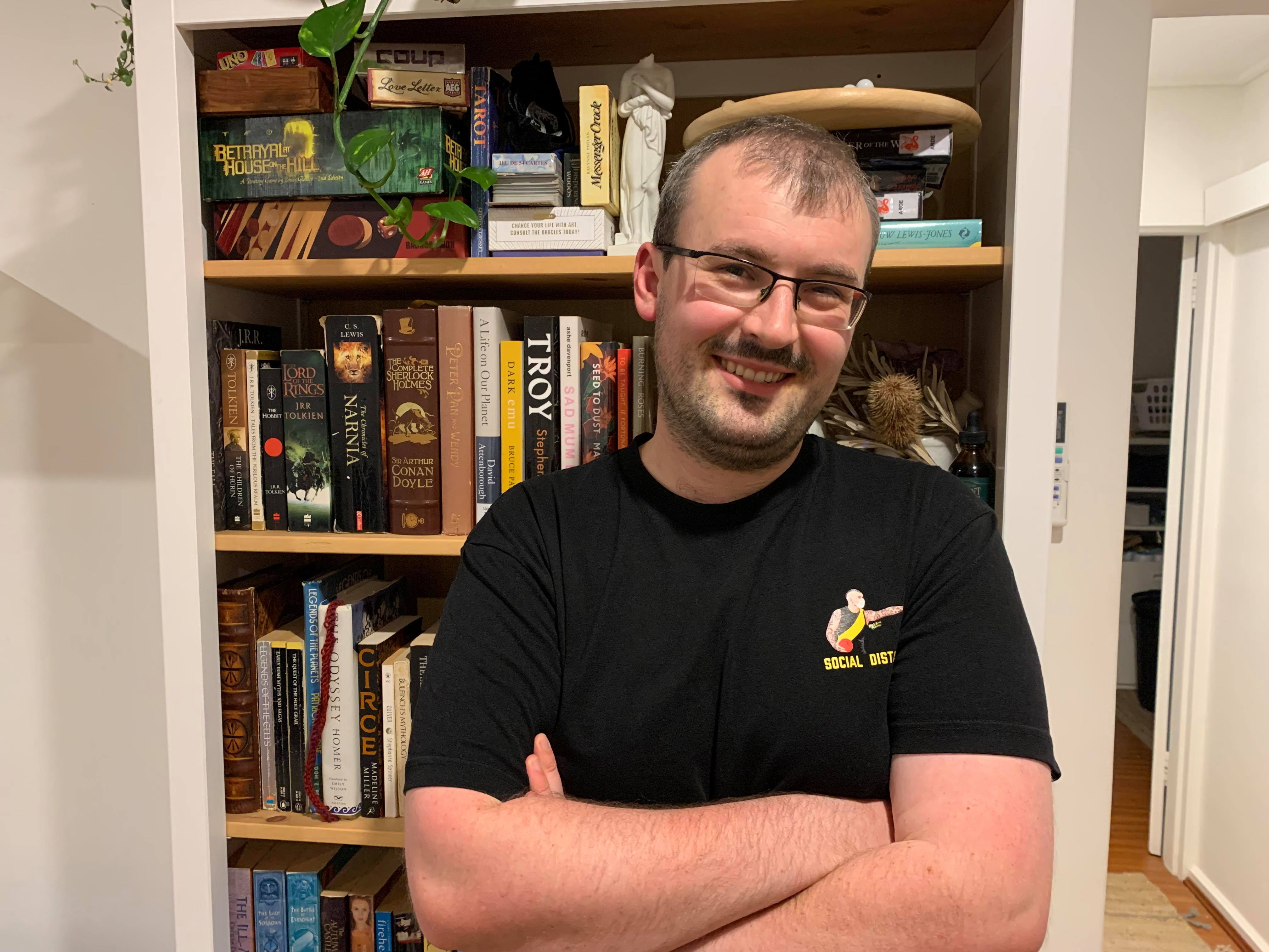 Tom Clift stands in his new apartment, smiling with his arms folded, in story about house-sitting pros and cons.