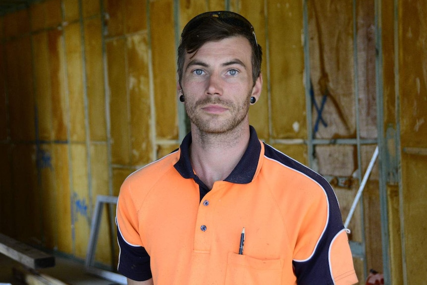 Neale McClure wearing a hi-vis shirt on a construction site.