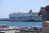 The carrier sits in dock, next to a jetty. The Key Integrity carrier, also in dock, is in the foreground.