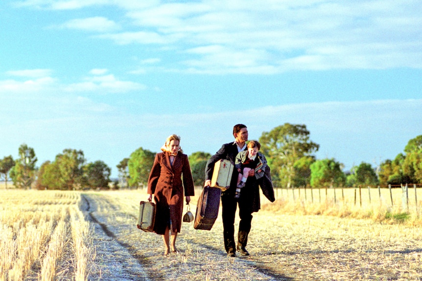 Family walk through dry grain paddocks on the set of Romulus, My Father