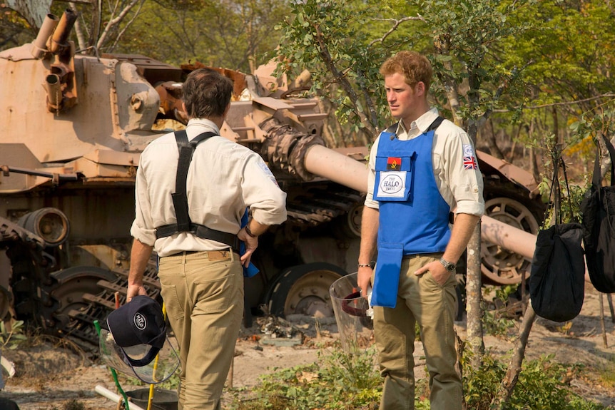 Britain's Prince Harry (R) and HALO Director Guy Willougby stand next to a South African Olifant tank from 1988 in Angola