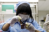 An employee works along a production line in Suzhou Etron Electrics Co. Ltd's factory in Suzhou.