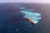 An oil slick spreads from a coal ship which ran aground on Douglas Shoal