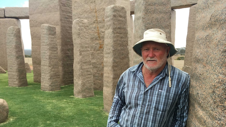 Kim Beale the owner of the Stonehenge replica near Esperance leans against the stone structure.