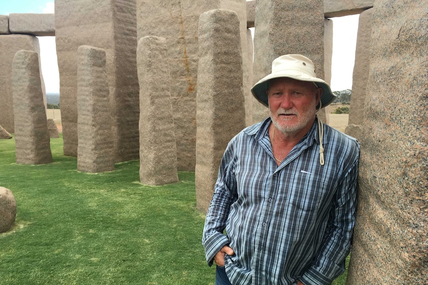 Kim Beale the owner of the Stonehenge replica near Esperance leans against the stone structure.