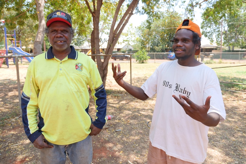 an Indigenous man and a teenager next to each other in playground