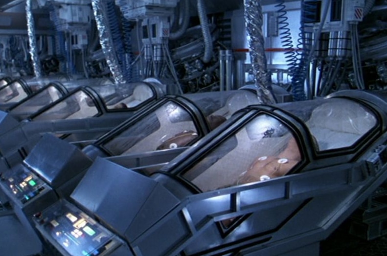 A still from the film Aliens showing a row of cryonic chambers containing frozen soldiers.