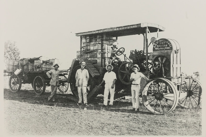 Old black-and-white image of men with a tractor.
