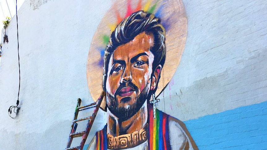 A mural on a house depicts singer George Michael as a saint with a rainbow halo.